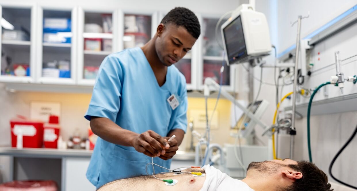 Man arriving to the emergency room and nurse placing electrodes